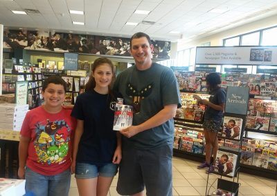 A family displays their copy of Beautiful Evil Winter at Kelly K. Lavender's Barnes & Noble Booksigning