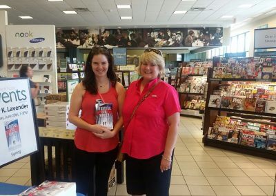 Two patrons display a copy of Beautiful Evil Winter at Kelly K. Lavender's Barnes & Noble Booksigning